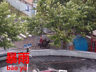 台風襲来した上海の走るバイク