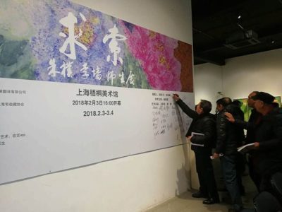 展示パネルにサインをする中国人